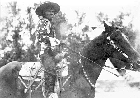 Jackson Sundown on his horse, note beaded glove cuffs.