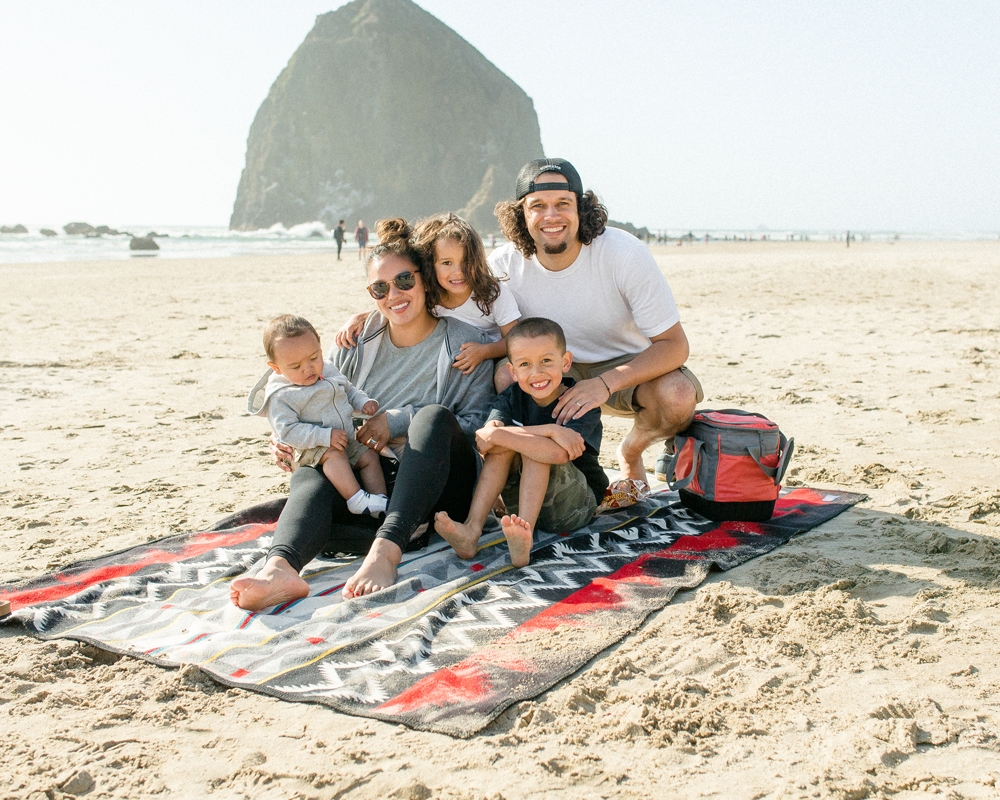 A family sits on their Pendleton blanket at Cannon Beach