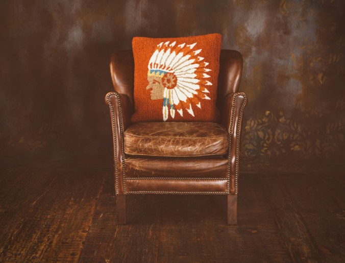A leather chair and hooked wool pillow by BrandonBurkPhotography.com