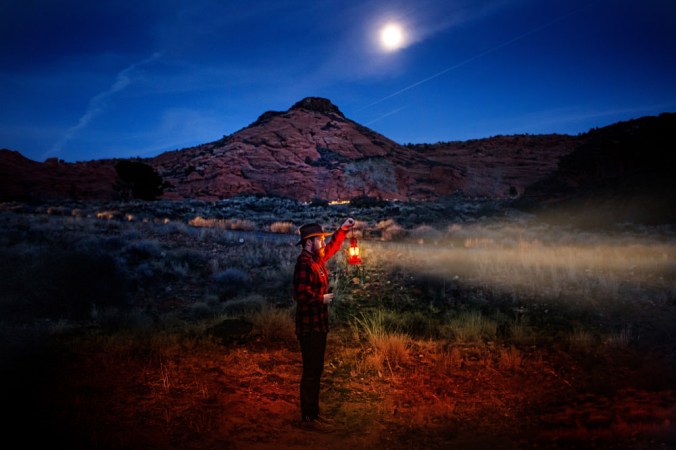 BrandonBurkPhotography.com A man poses with a lantern in the Utah desert at night. 