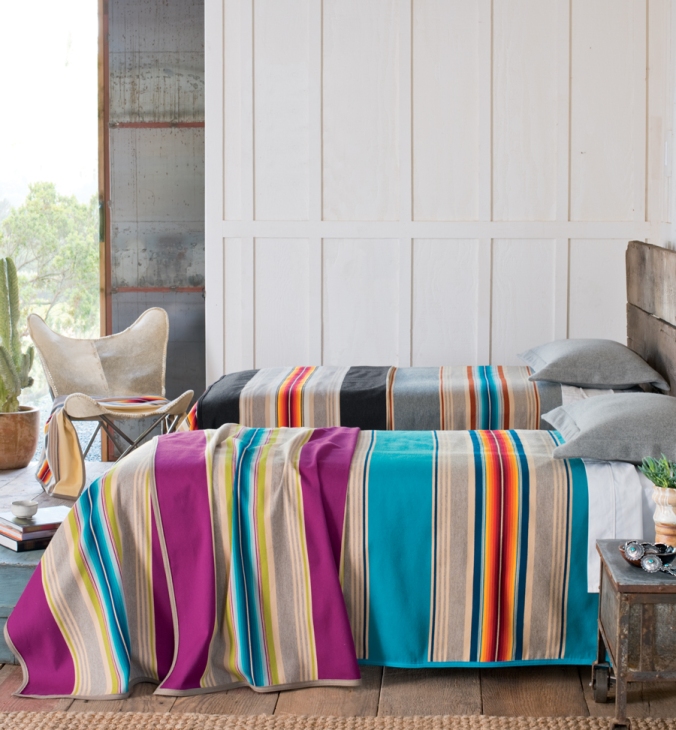 Serape-blankets on beds in a beachy room.